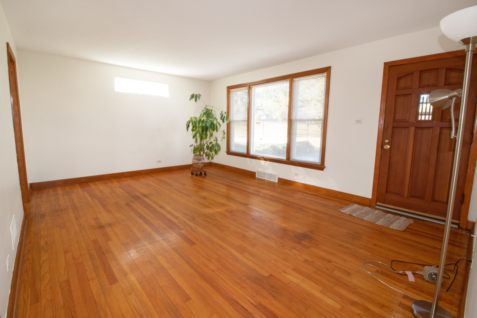 215 Iroquois Road Hillside, IL 60162 - Photo 3 of 26 a view of an empty room with wooden floor and a window