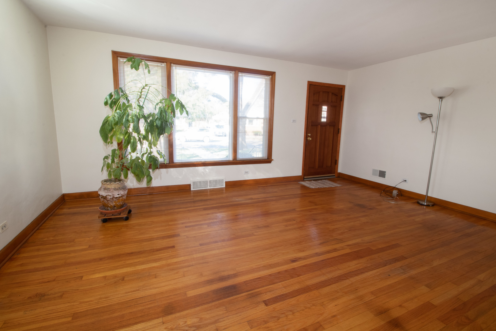 215 Iroquois Road Hillside, IL 60162 - Photo 4 of 26 a view of an empty room with wooden floor and a window