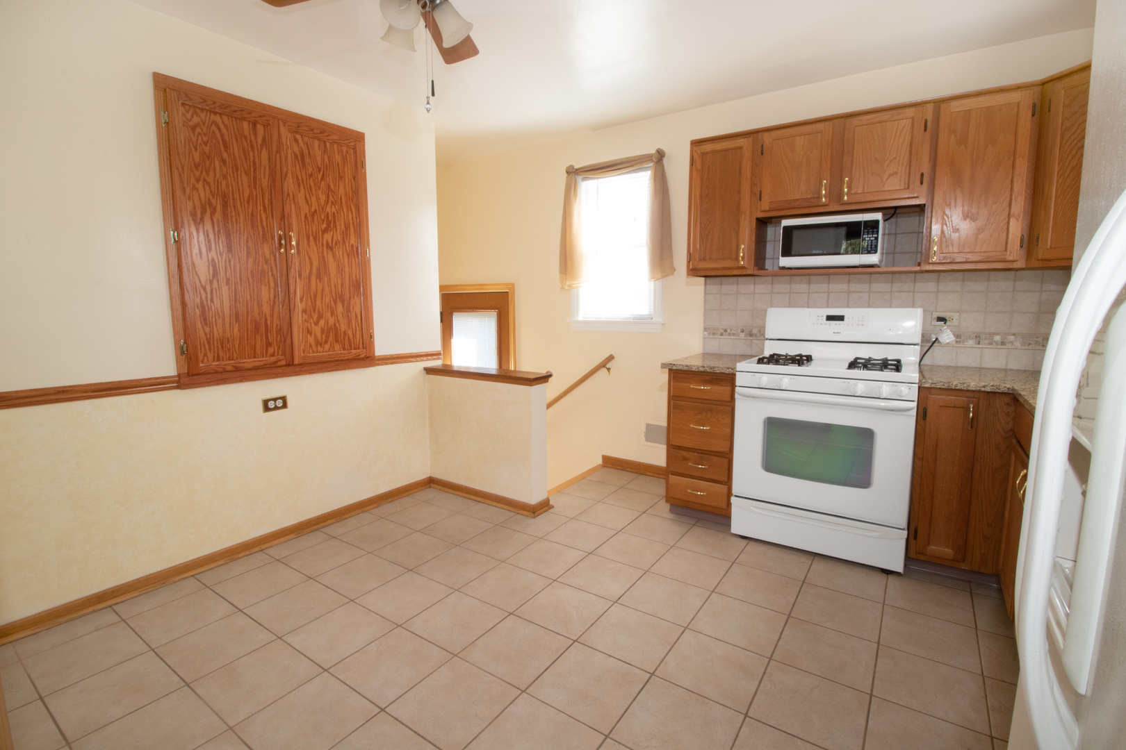 215 Iroquois Road Hillside, IL 60162 - Photo 5 of 26 a kitchen with white cabinets and stainless steel appliances