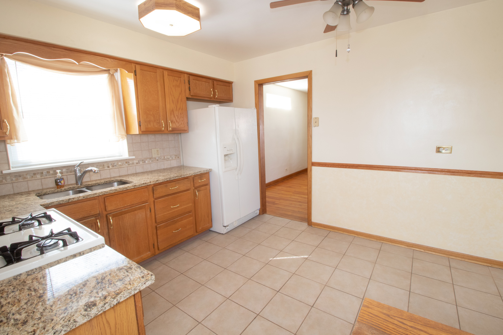215 Iroquois Road Hillside, IL 60162 - Photo 7 of 26 a kitchen with a stove a sink and a refrigerator
