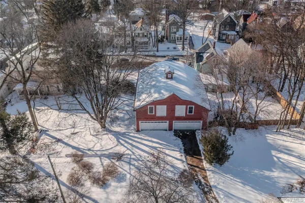 a front view of a house with a yard covered in snow