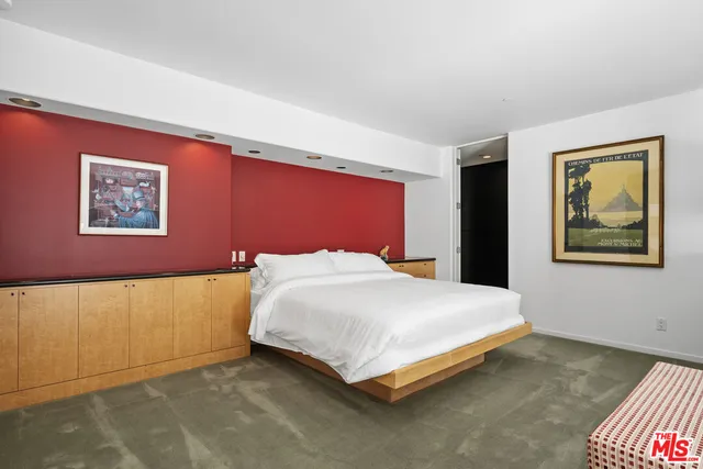 a bedroom with a bed and painting on the wall