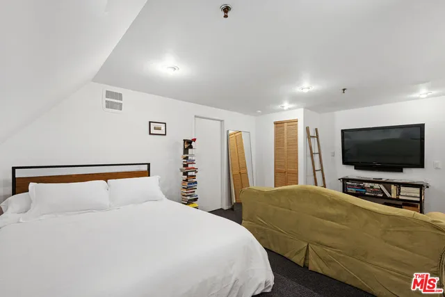 a bedroom with a bed and a flat screen tv