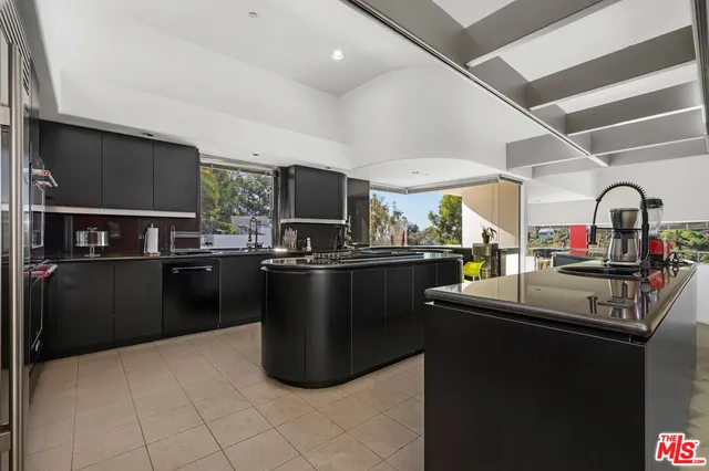 a kitchen with kitchen island granite countertop a sink dishwasher stove and refrigerator
