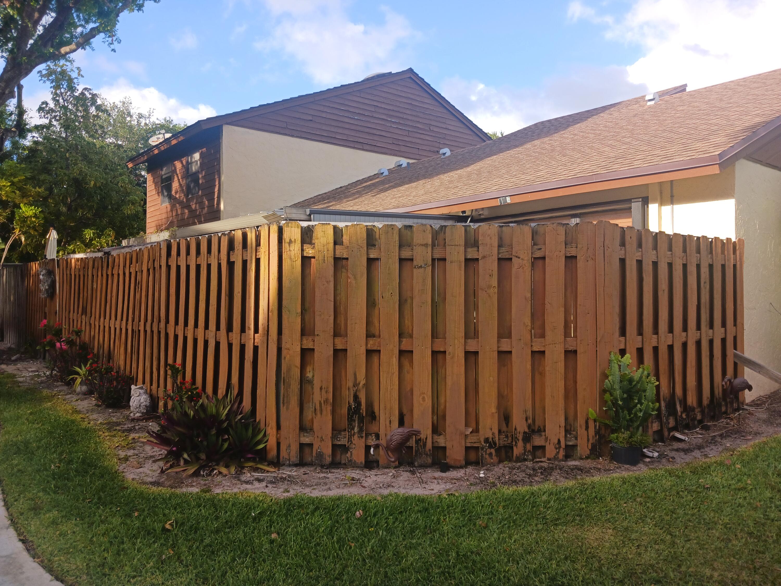 4403 Rende Lane Lake Worth, FL 33461 - Photo 8 of 14 a view of a backyard with potted plants and wooden fence