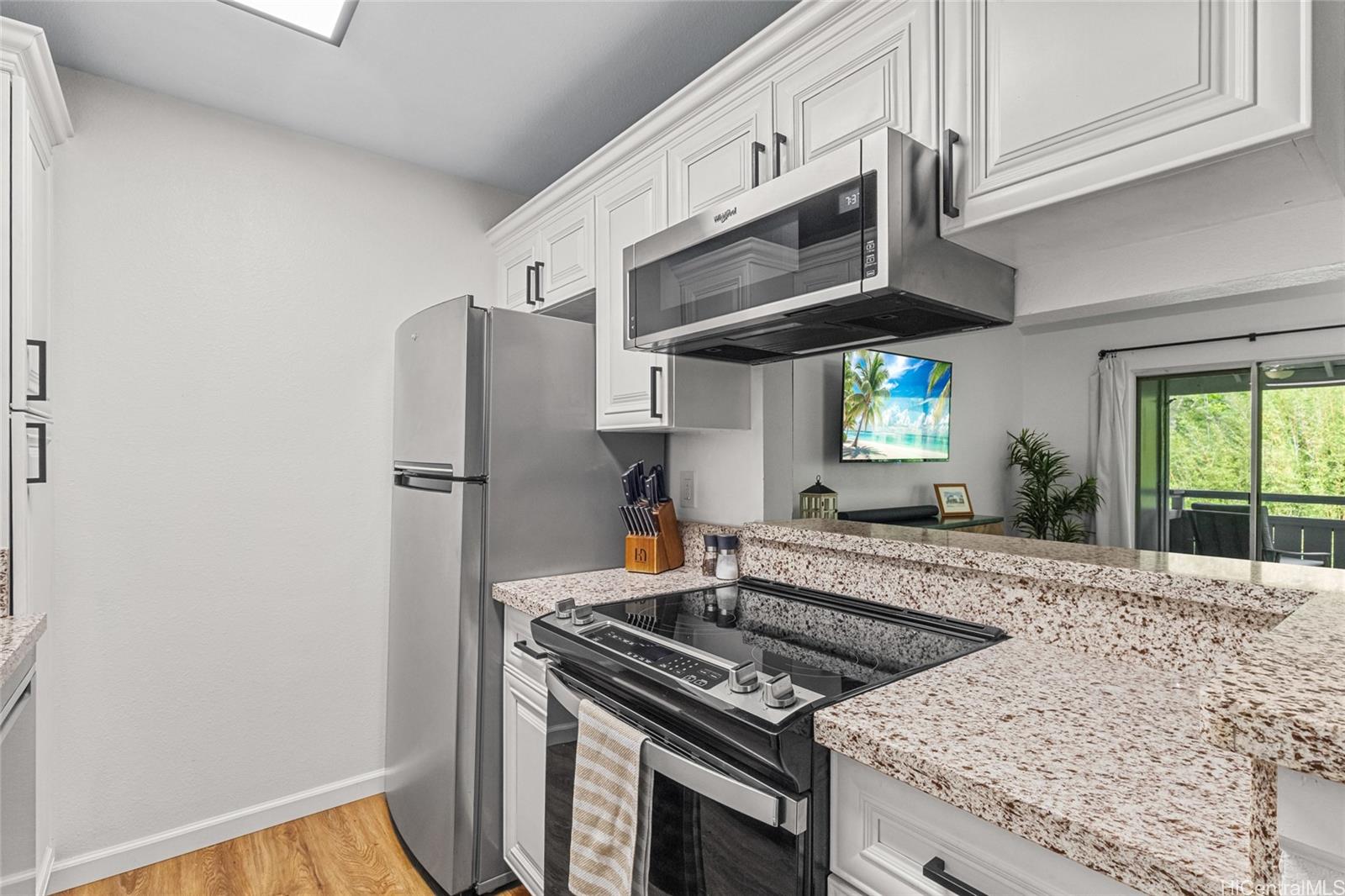 95-660 Wikao Street, Unit K304 Mililani, HI 96789 - Photo 5 of 24 a kitchen with stainless steel appliances granite countertop a stove and a refrigerator