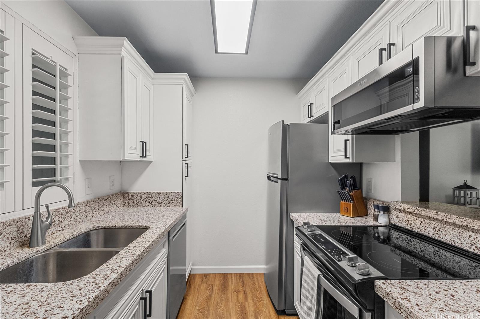 95-660 Wikao Street, Unit K304 Mililani, HI 96789 - Photo 7 of 24 a kitchen with stainless steel appliances granite countertop a sink stove and refrigerator