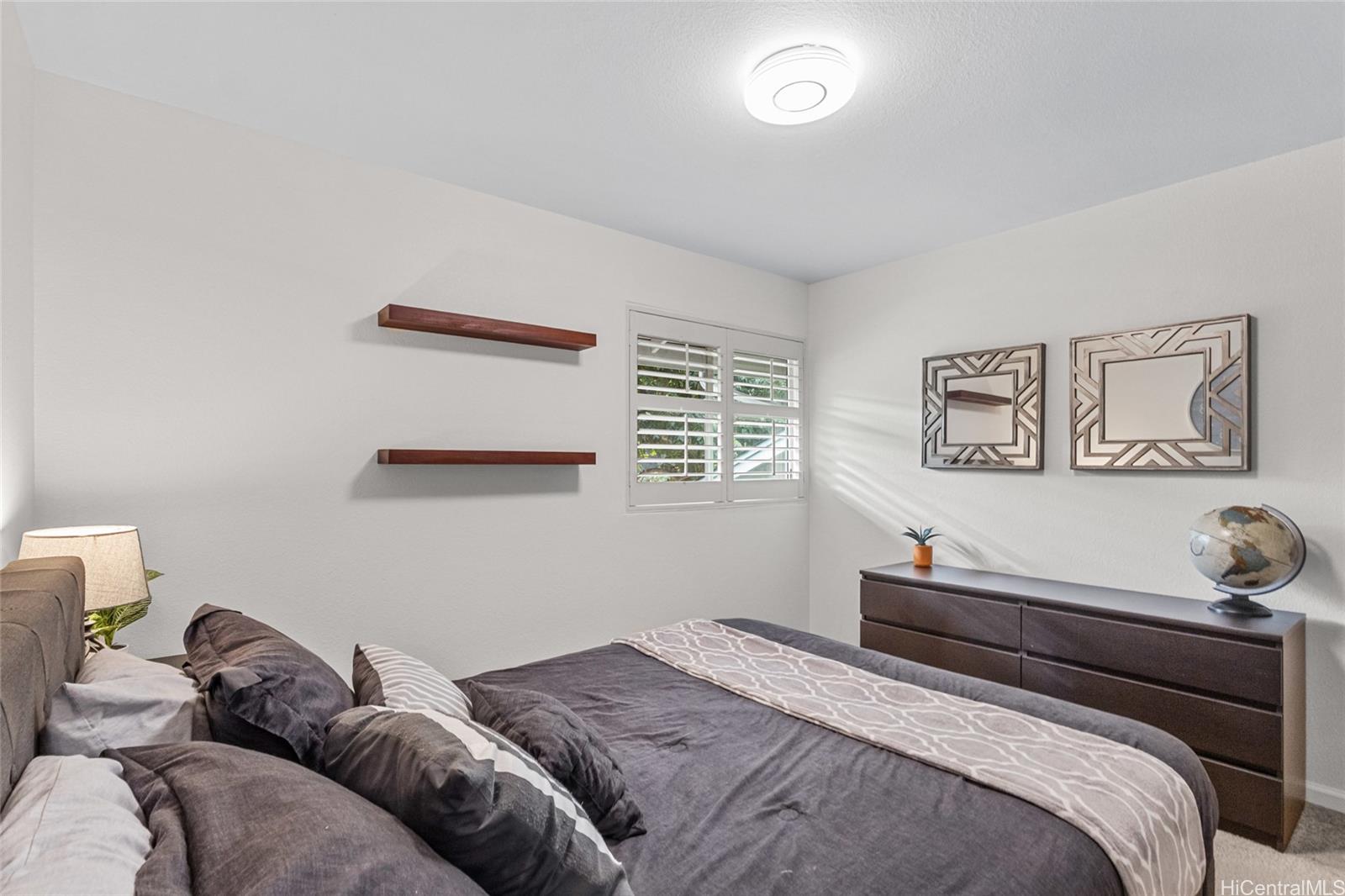 95-660 Wikao Street, Unit K304 Mililani, HI 96789 - Photo 9 of 24 a bedroom with a bed and a wall painting