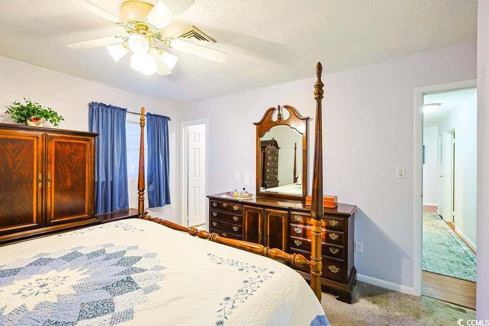 801 Talbot Circle Myrtle Beach, SC 29577 - Photo 15 of 40 Bedroom with light carpet, a ceiling fan, and a textured ceiling