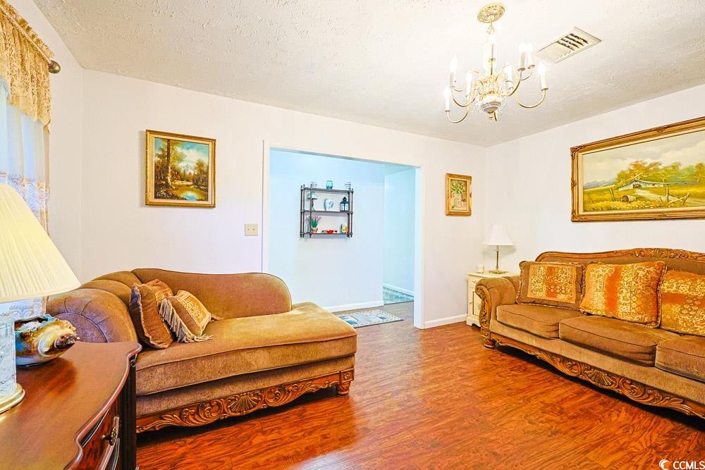 801 Talbot Circle Myrtle Beach, SC 29577 - Photo 20 of 40 Living room with a textured ceiling, wood finished floors, and a chandelier