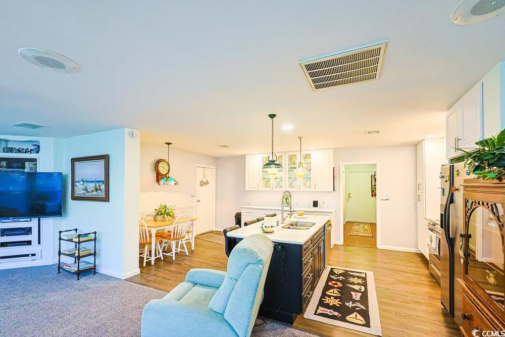 801 Talbot Circle Myrtle Beach, SC 29577 - Photo 6 of 40 Kitchen with white cabinets, decorative light fixtures, light stone countertops, stainless steel appliances, and glass insert cabinets