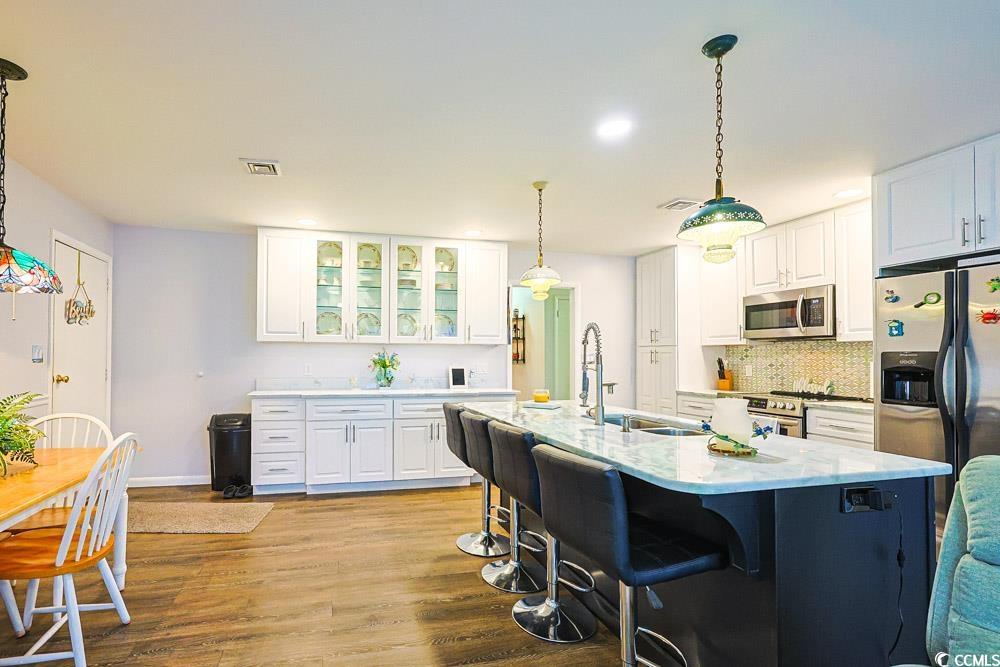 801 Talbot Circle Myrtle Beach, SC 29577 - Photo 8 of 40 Kitchen featuring decorative light fixtures, white cabinets, stainless steel appliances, dark wood finished floors, and recessed lighting