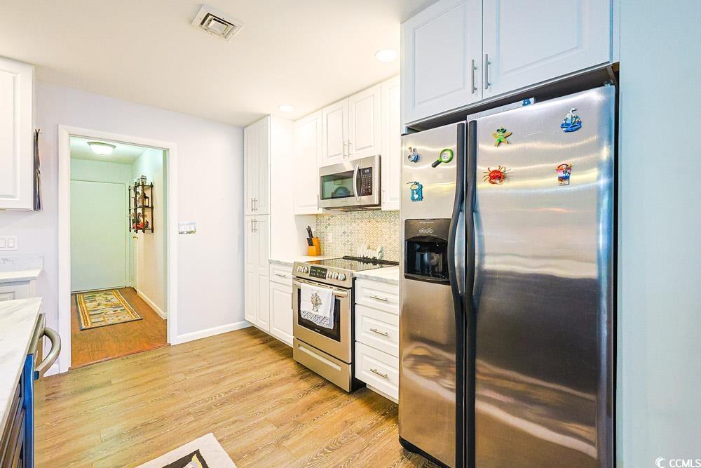 801 Talbot Circle Myrtle Beach, SC 29577 - Photo 9 of 40 Kitchen featuring stainless steel appliances, white cabinets, tasteful backsplash, light wood-style floors, and recessed lighting
