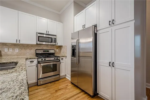 a kitchen with cabinets stainless steel appliances and a counter space