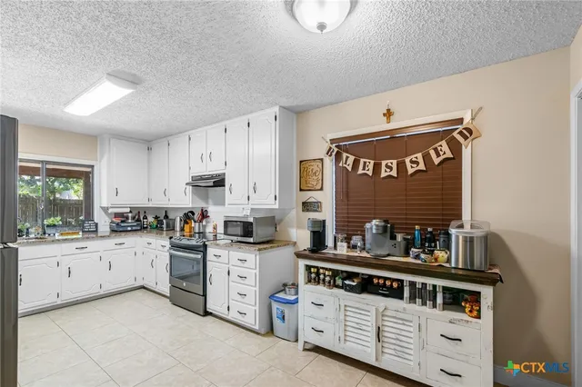 a kitchen with stainless steel appliances a stove a sink and cabinets