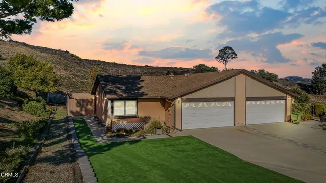 a front view of a house with a garden and plants