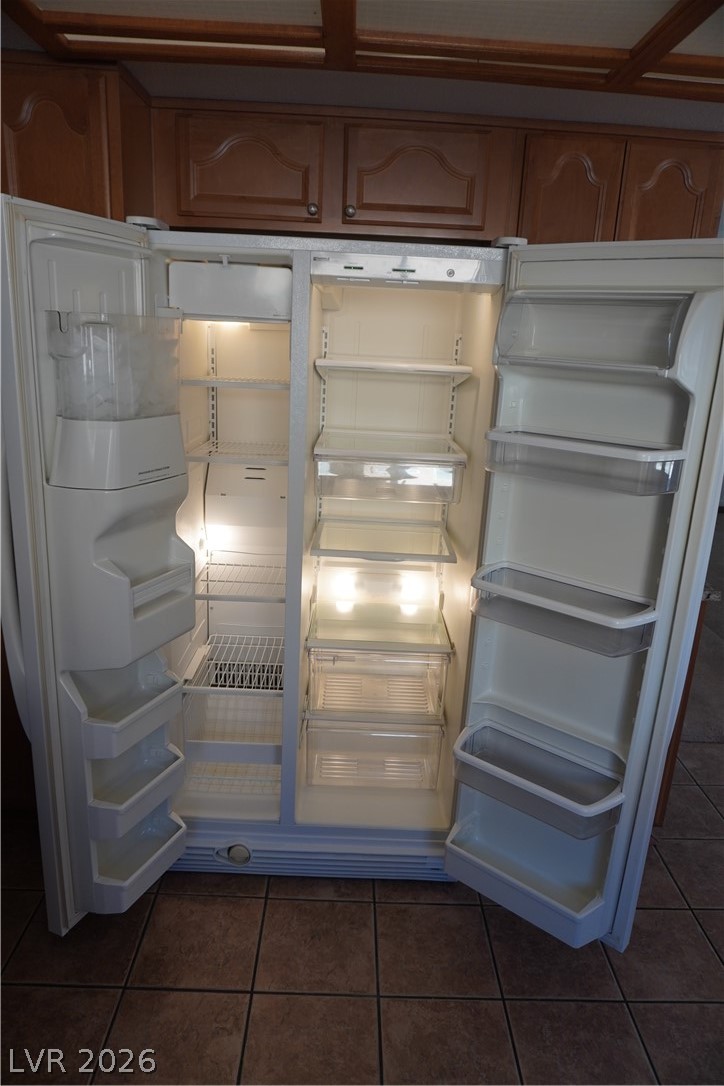8328 Del Rey Avenue Las Vegas, NV 89117 - Photo 14 of 38 A side-by-side refrigerator offers ample storage, seamlessly integrated with wooden cabinetry.