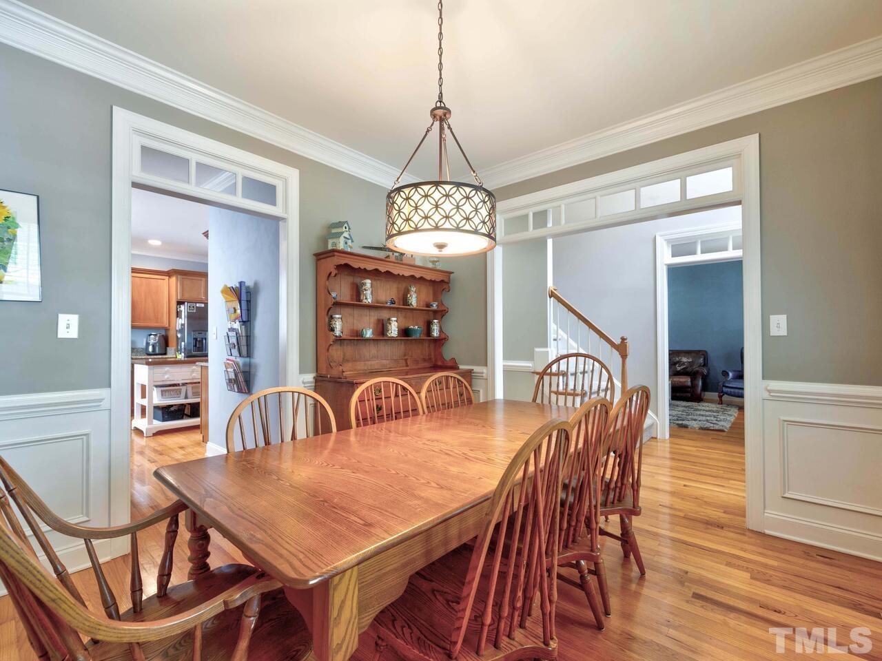 2228 Karns Place Raleigh, NC 27614 - Photo 9 of 62 a dining room with furniture a chandelier and wooden floor