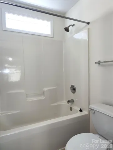 a bathroom with a toilet and a bath tub