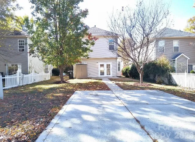 a view of a white house with a yard and large tree