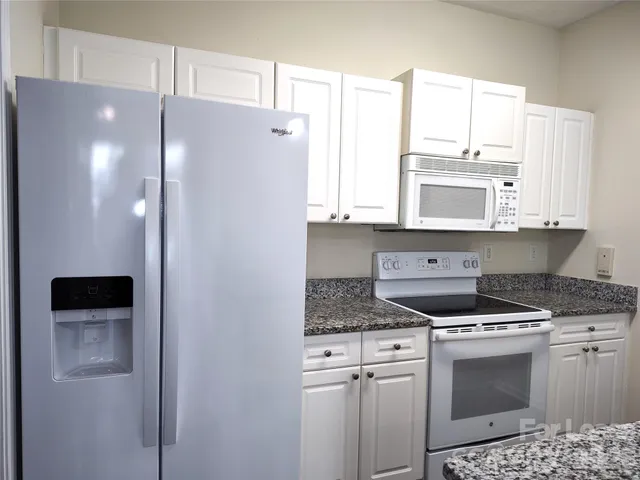 a kitchen with stainless steel appliances white cabinets and a refrigerator