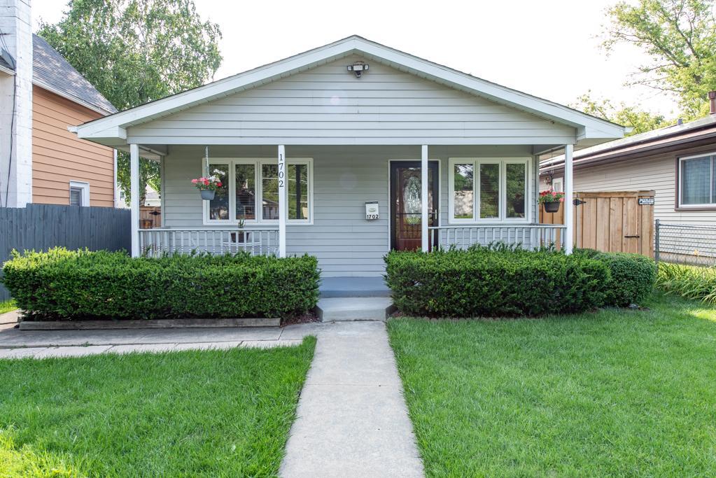 1702 Hebron Avenue Zion, IL 60099 - Photo 1 of 28 a front view of a house with a yard and potted plants