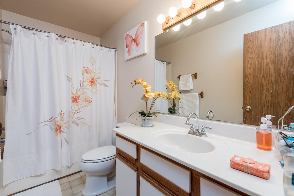 1702 Hebron Avenue Zion, IL 60099 - Photo 15 of 28 a bathroom with a granite countertop sink a toilet and shower curtain