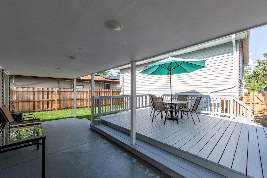 1702 Hebron Avenue Zion, IL 60099 - Photo 23 of 28 a view of a patio with table and chairs under an umbrella with wooden floor
