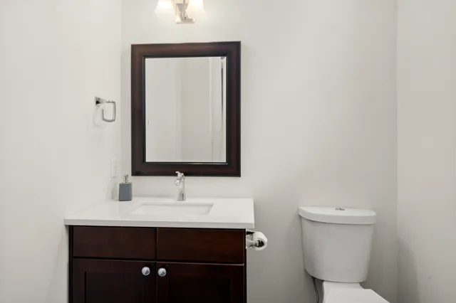 a bathroom with a bathtub shower sink vanity mirror and toilet