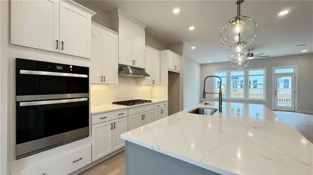 a kitchen with a sink a counter space and wooden floor