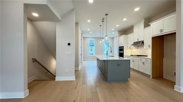 a large kitchen with a large counter top cabinets and stainless steel appliances
