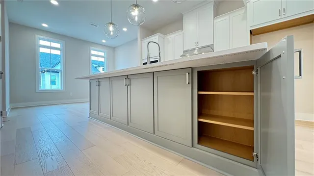 a kitchen with kitchen island white cabinets and refrigerator
