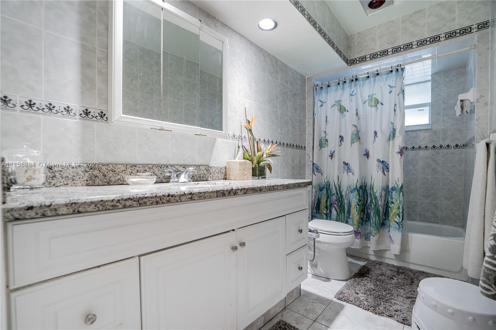 5012 Hayes Street Hollywood, FL 33021 - Photo 15 of 36 a bathroom with a granite countertop sink a toilet and shower