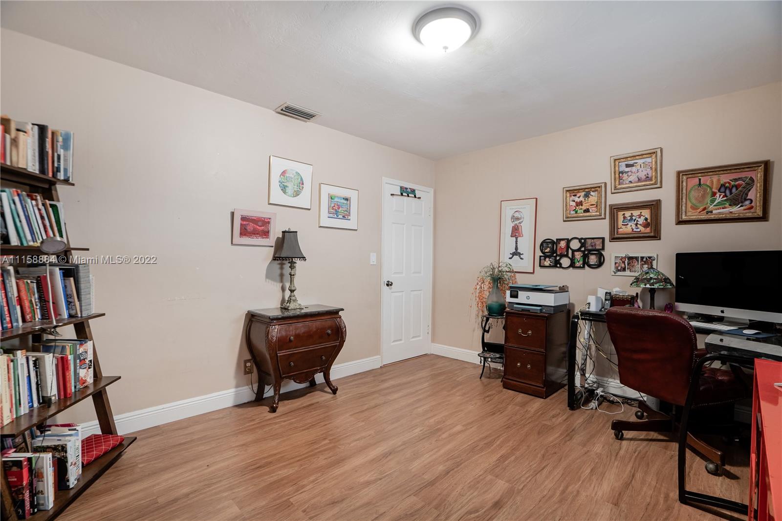 5012 Hayes Street Hollywood, FL 33021 - Photo 19 of 36 a view of a workspace with bookshelf and a window