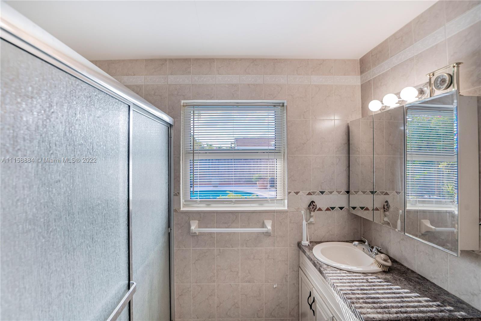 5012 Hayes Street Hollywood, FL 33021 - Photo 24 of 36 a bathroom with a window and a shower