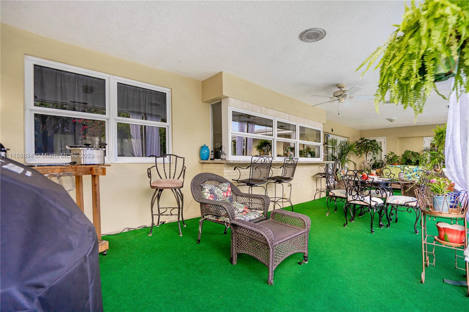 5012 Hayes Street Hollywood, FL 33021 - Photo 28 of 36 a view of a backyard with table and chairs potted plants and large tree