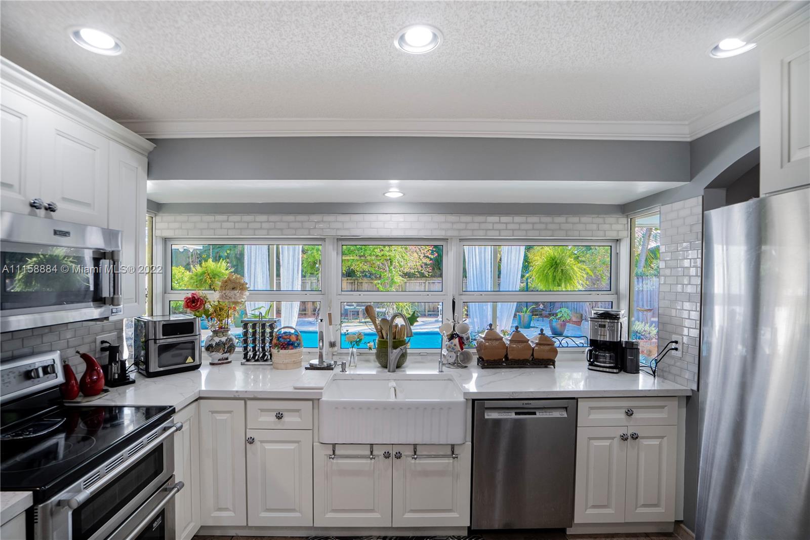 5012 Hayes Street Hollywood, FL 33021 - Photo 10 of 36 a kitchen with stainless steel appliances a sink window and cabinets