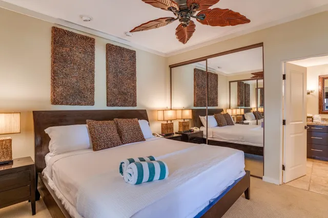 a bedroom with a large bed and a chandelier