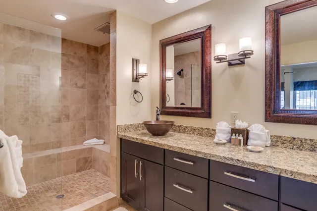 a bathroom with a granite countertop sink and a mirror