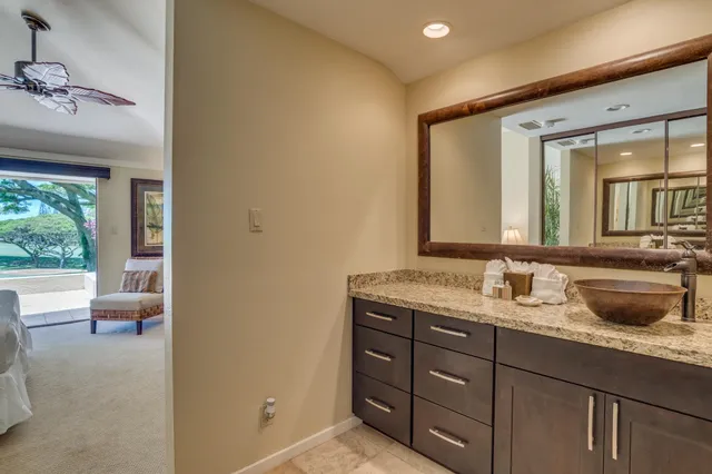 a bathroom with a granite countertop sink mirror vanity and toilet