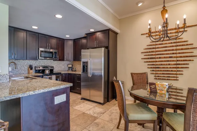 a kitchen with stainless steel appliances granite countertop a refrigerator a sink a stove a dining table and chairs