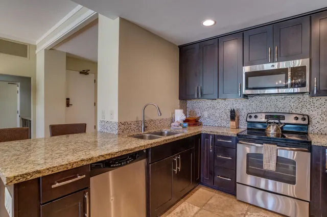 a kitchen with stainless steel appliances granite countertop a stove sink and cabinets