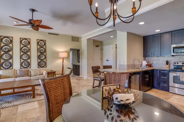a living room with furniture kitchen view and a large window