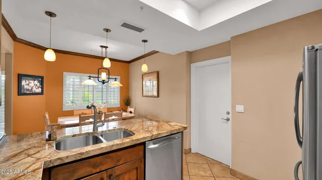 a kitchen with stainless steel appliances granite countertop a sink refrigerator and cabinets