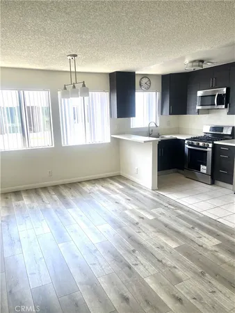a large kitchen with kitchen island granite countertop a wooden cabinets and a stove top oven