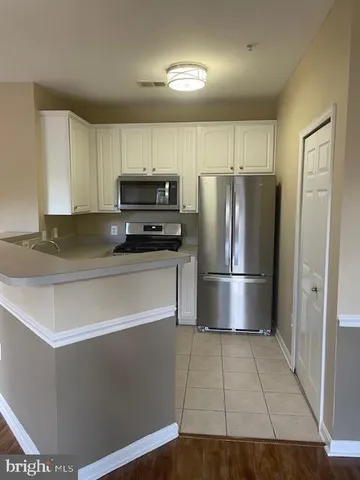 a kitchen with granite countertop a refrigerator and a stove top oven