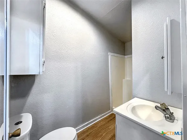 a bathroom with a granite countertop sink a mirror and a toilet