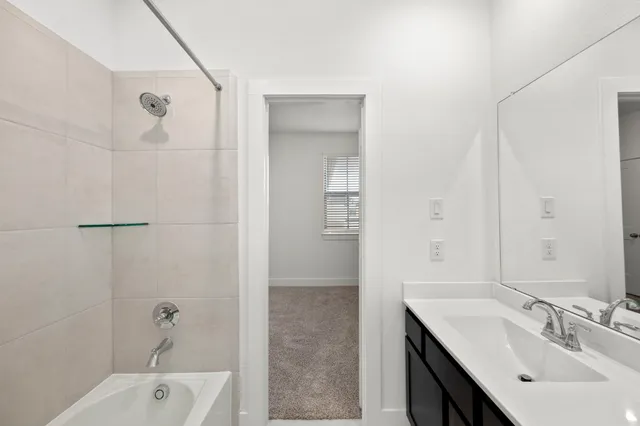 a bathroom with a tub sink and mirror