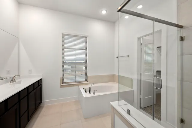 a spacious bathroom with a tub shower and sink