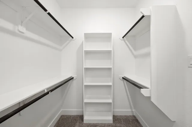 a view of walk in closet with empty racks